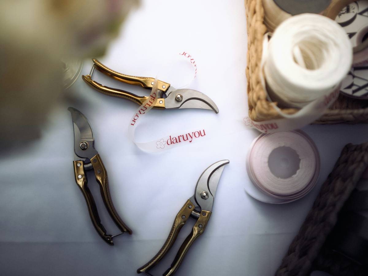 Hands using a clear plastic protractor to measure the angle of a red-and-gold festive garland on a wooden mantel, demonstrating festive decoration protractor how to use